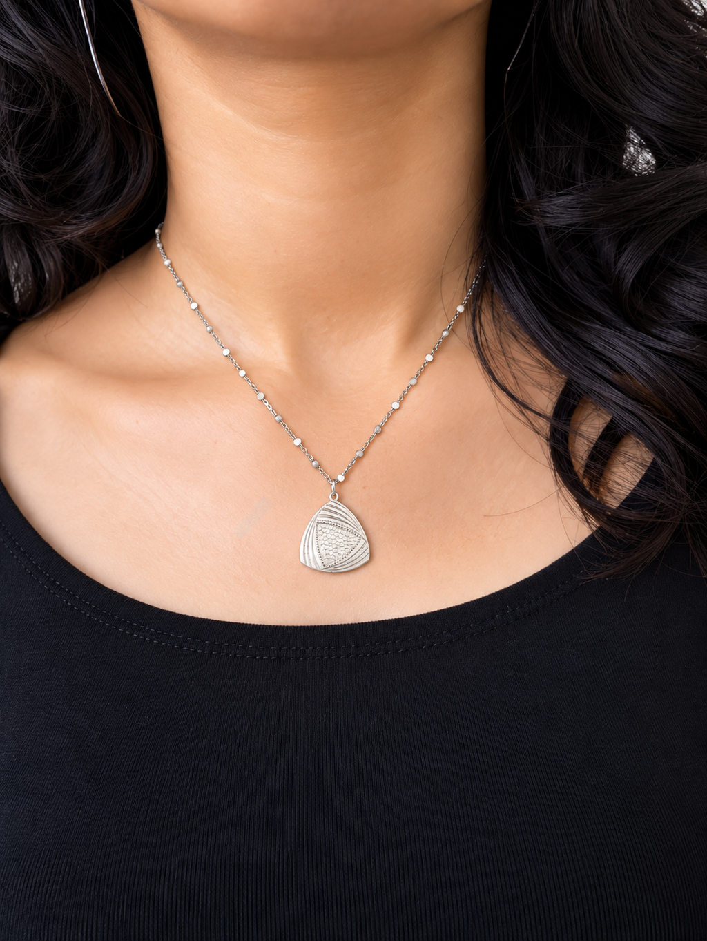 A model wearing a cosmic triangle pendant chain with a black top