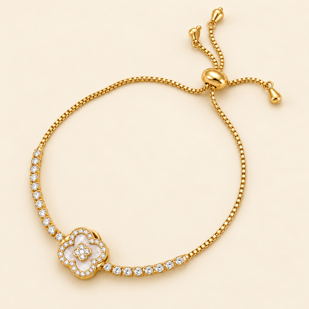 Gold-toned stainless steel slider bracelet featuring a four-leaf clover motif outlined with sparkling white stones and a floral centre.
Delicate gold chain with clear stone accents and an adjustable slider closure, displayed on a background.pink