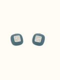 A pair of square stud earrings with a muted teal-blue enamel body and a central silver-toned square set with clear pavé stones, shown on a plain off-white background.