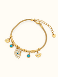 Gold-toned stainless steel charm bracelet featuring blue evil eye motifs, turquoise-coloured accents and an eye-shaped charm with sparkling white stones.
Decorative gold beads and a delicate chain with an adjustable extension, displayed on a clean white background.