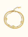 Gold-toned layered bracelet featuring three round openwork Tree of Life-inspired charms and small bead accents.
Designed with a sleek snake chain, delicate link chain and adjustable lobster clasp on a plain white background.