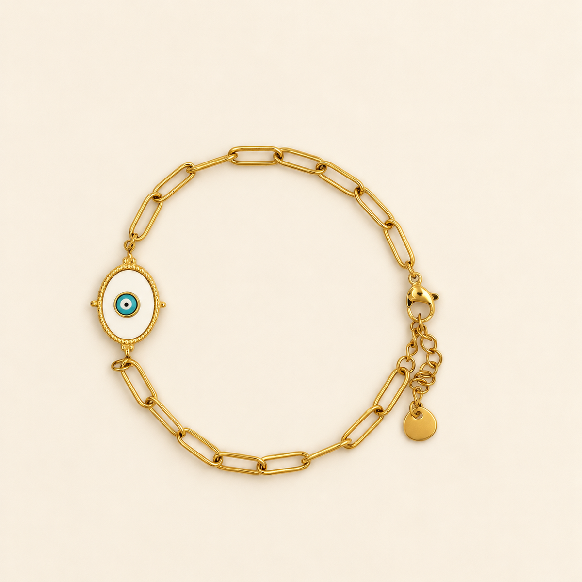 Gold-toned stainless steel bracelet featuring elongated chain links and an oval white enamel charm with a blue evil eye motif.
Gold-link bracelet with a textured border and adjustable extension, displayed on a clean pink background.