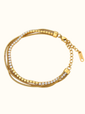 Gold-toned stainless steel multi-strand bracelet featuring clear sparkling stones and polished square accents.
Layered chain bracelet with an adjustable extension and lobster clasp, displayed on a clean white background.