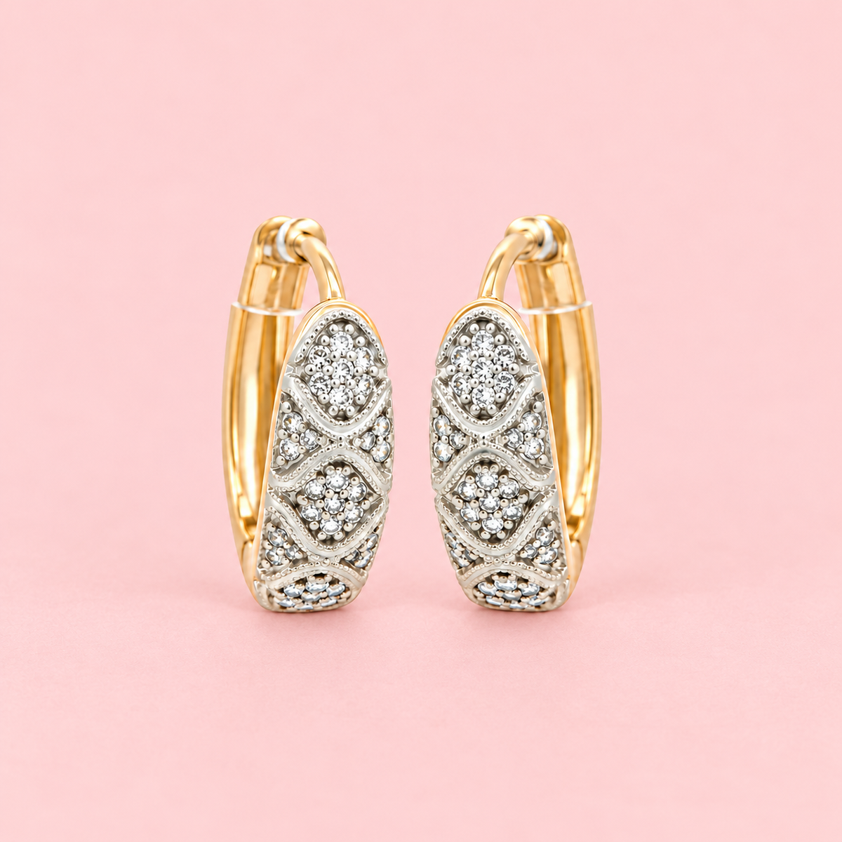 Rose Gold-tone vintage-inspired hoop earrings with clear zircon stones, double oval motifs and intricate detailing displayed against a pink background.