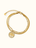 Gold-toned layered bracelet featuring a round Tree of Life charm with a border of clear sparkling stones.
Designed with a snake chain, rectangular-link chain and an adjustable extension clasp on a plain white background.