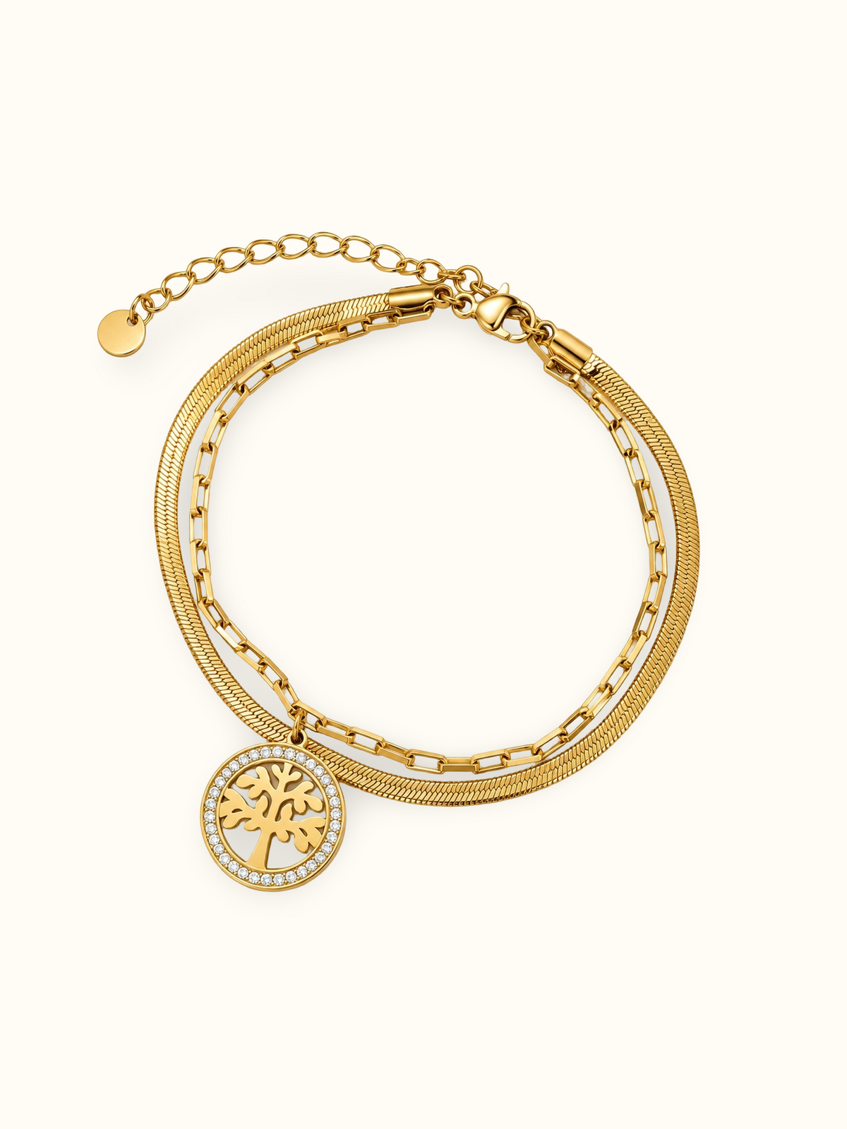 Gold-toned layered bracelet featuring a round Tree of Life charm with a border of clear sparkling stones.
Designed with a snake chain, rectangular-link chain and an adjustable extension clasp on a plain white background.