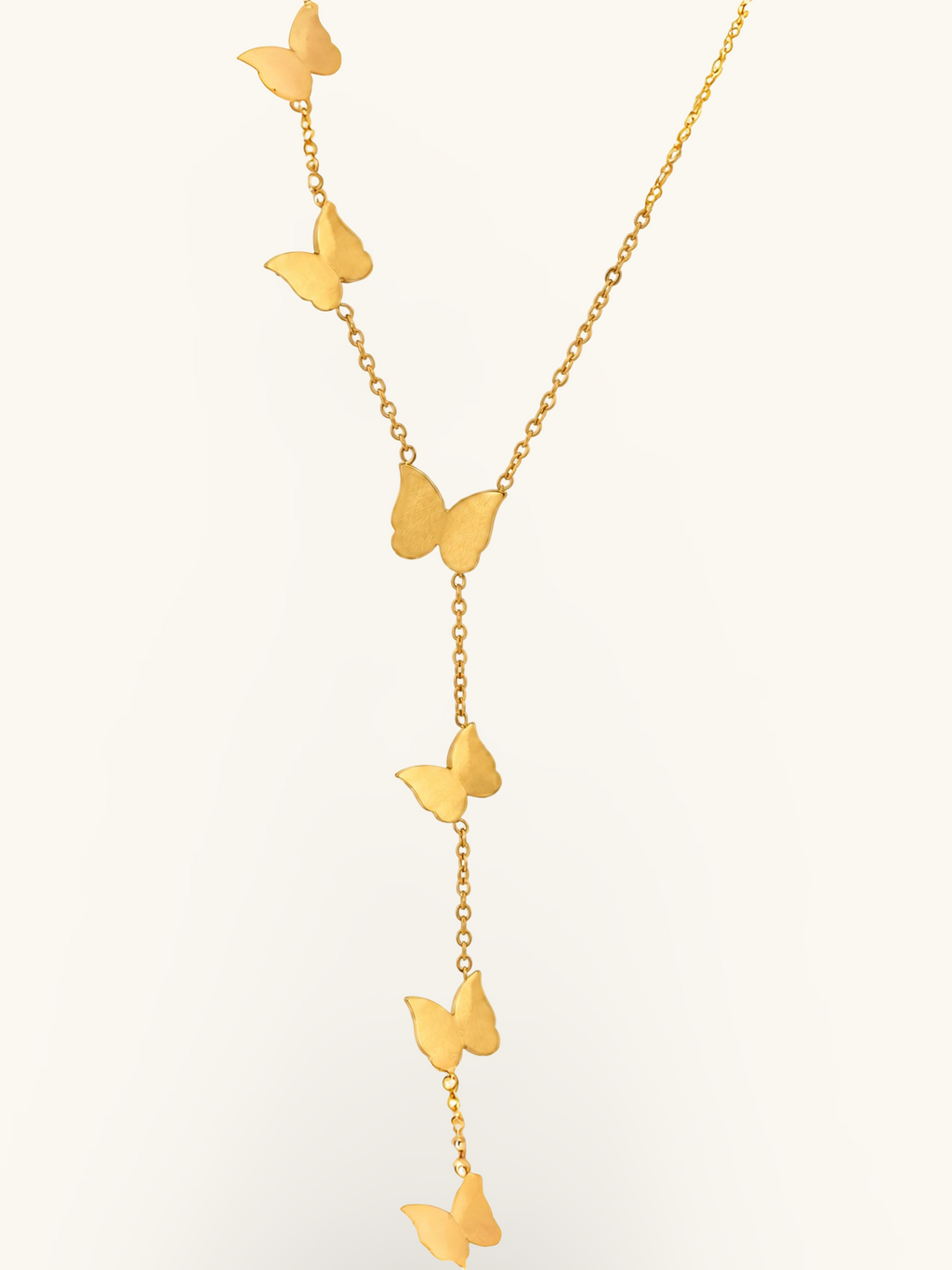 Gold-toned butterfly lariat necklace featuring three smooth butterfly charms arranged along a delicate cascading chain.

Close-up of a gold butterfly necklace with a central butterfly and two dangling butterfly charms against a white background.