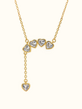 Gold-toned heart lariat necklace featuring four sparkling heart-shaped stones across the neckline and one dangling heart pendant.

Romantic cascading necklace with polished gold-toned settings and clear heart-shaped stones against a white background.