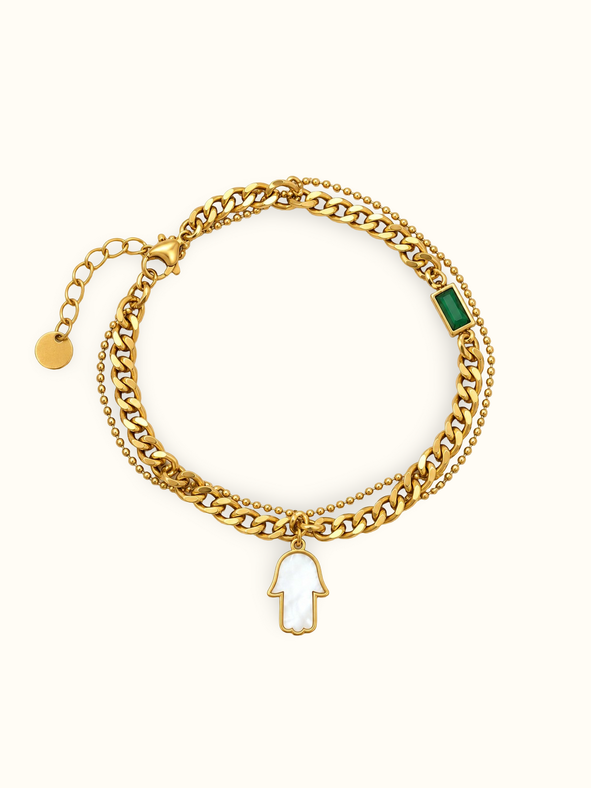 Gold-toned layered bracelet featuring a green rectangular accent and a white Hamsa hand charm.
Designed with chunky curb links, a delicate beaded chain and an adjustable extension clasp on a white background.