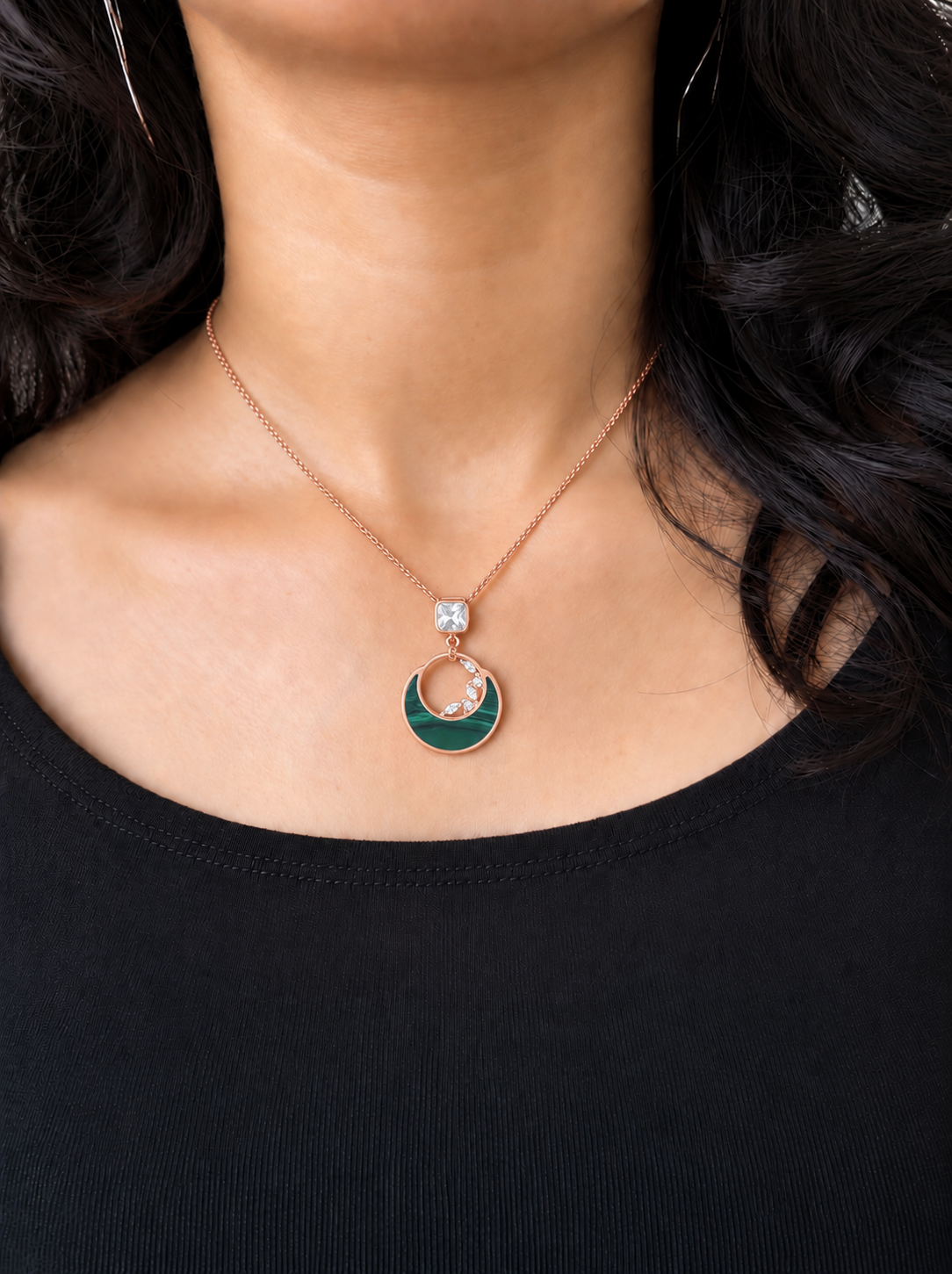 Model wearing a rose gold green moon pendant and chain with a black top