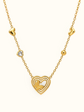 Gold-toned necklace featuring a layered open-heart pendant with a textured butterfly detail, a sparkling heart accent and polished heart-shaped elements along the chain.

Close-up of a delicate gold heart and butterfly necklace displayed against a clean white background.