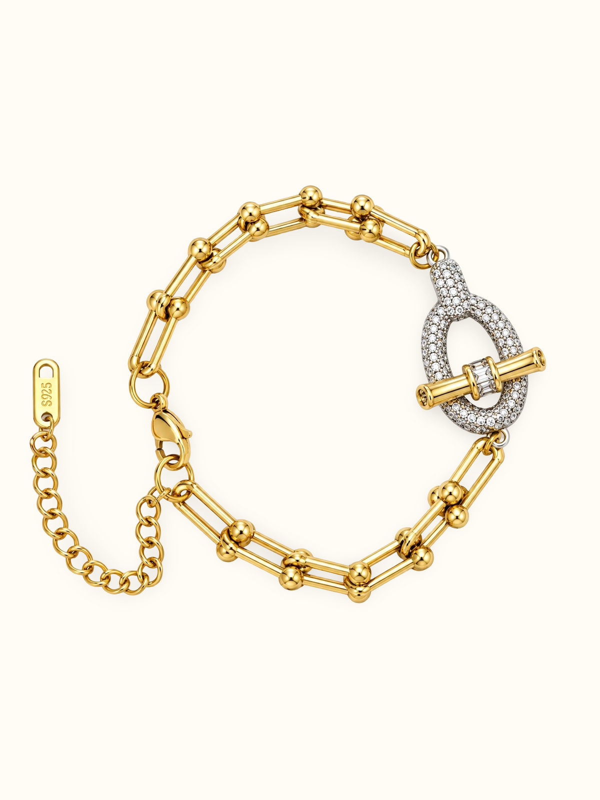 Gold-toned stainless steel bracelet featuring elongated geometric links and a pavé-set oval centrepiece crossed by a polished bar.
Statement bracelet with an adjustable chain and mixed gold-and-silver detailing, displayed on a clean white background.