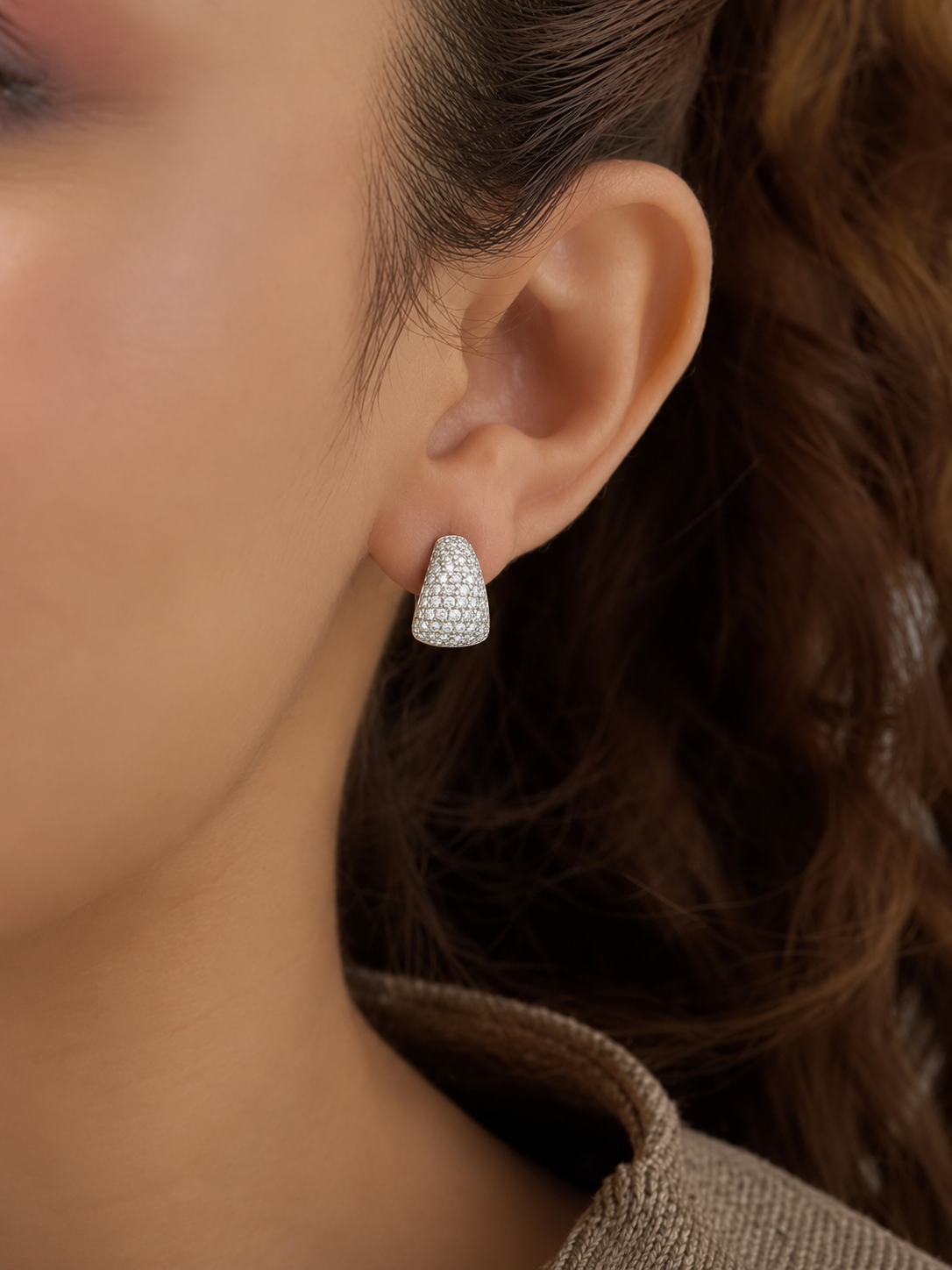 Silver-tone teardrop stud earrings with pavé-style white stones and a polished finish worn by a model.