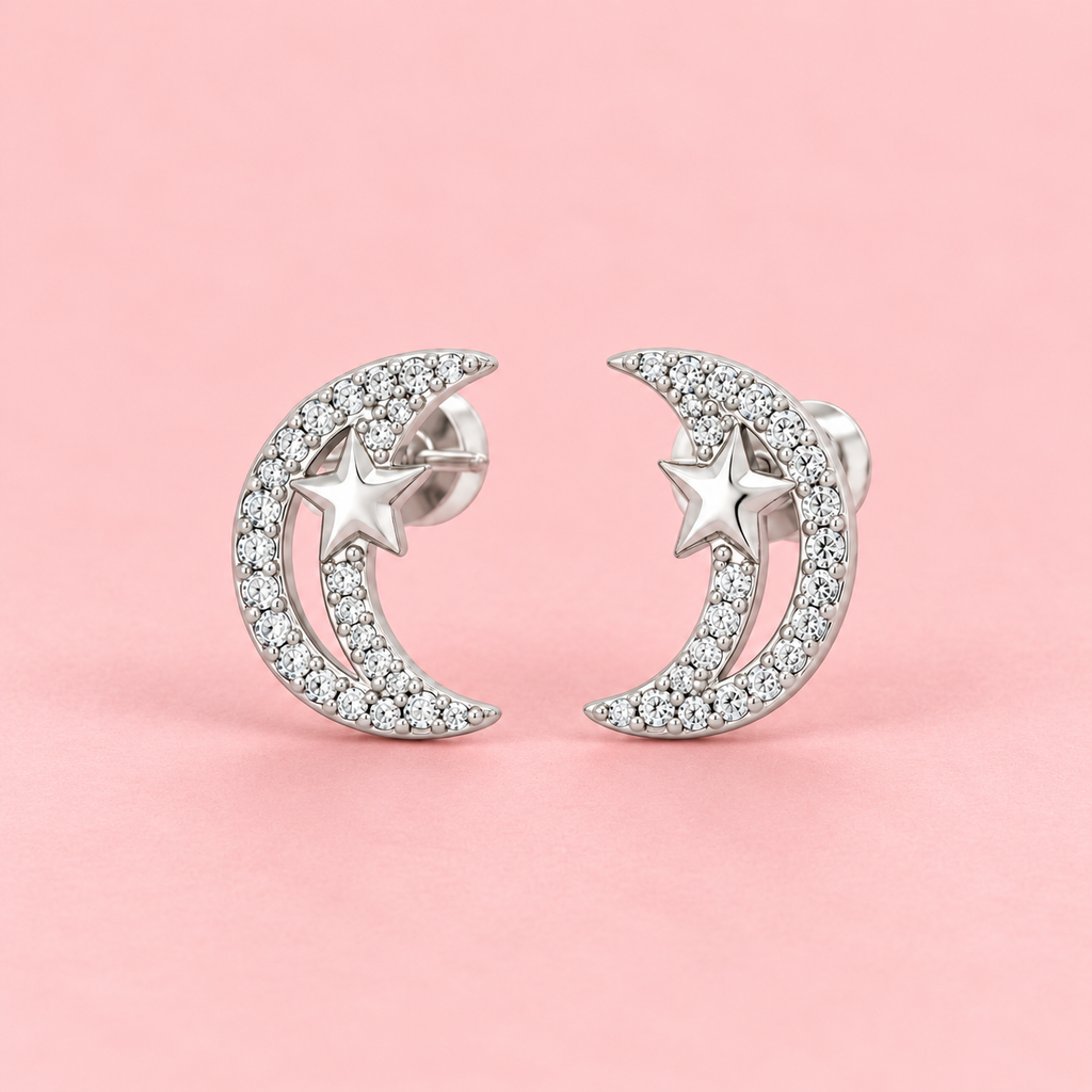 Silver crescent moon and star zircon stud earrings displayed against a soft pink background.