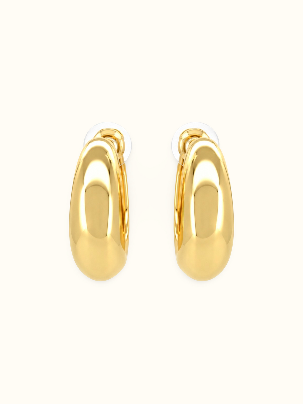 Polished gold-tone chunky crescent hoop earrings with a smooth, glossy finish and minimalist curved design displayed against a white background.