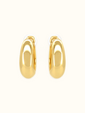 Polished gold-tone chunky crescent hoop earrings with a smooth, glossy finish and minimalist curved design displayed against a white background.