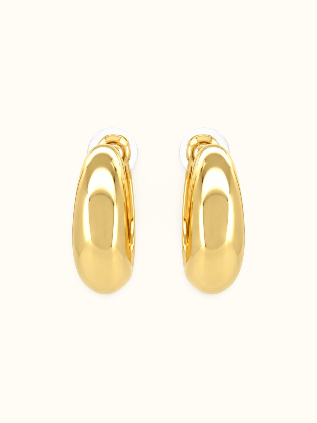 Polished gold-tone chunky crescent hoop earrings with a smooth, glossy finish and minimalist curved design displayed against a white background.