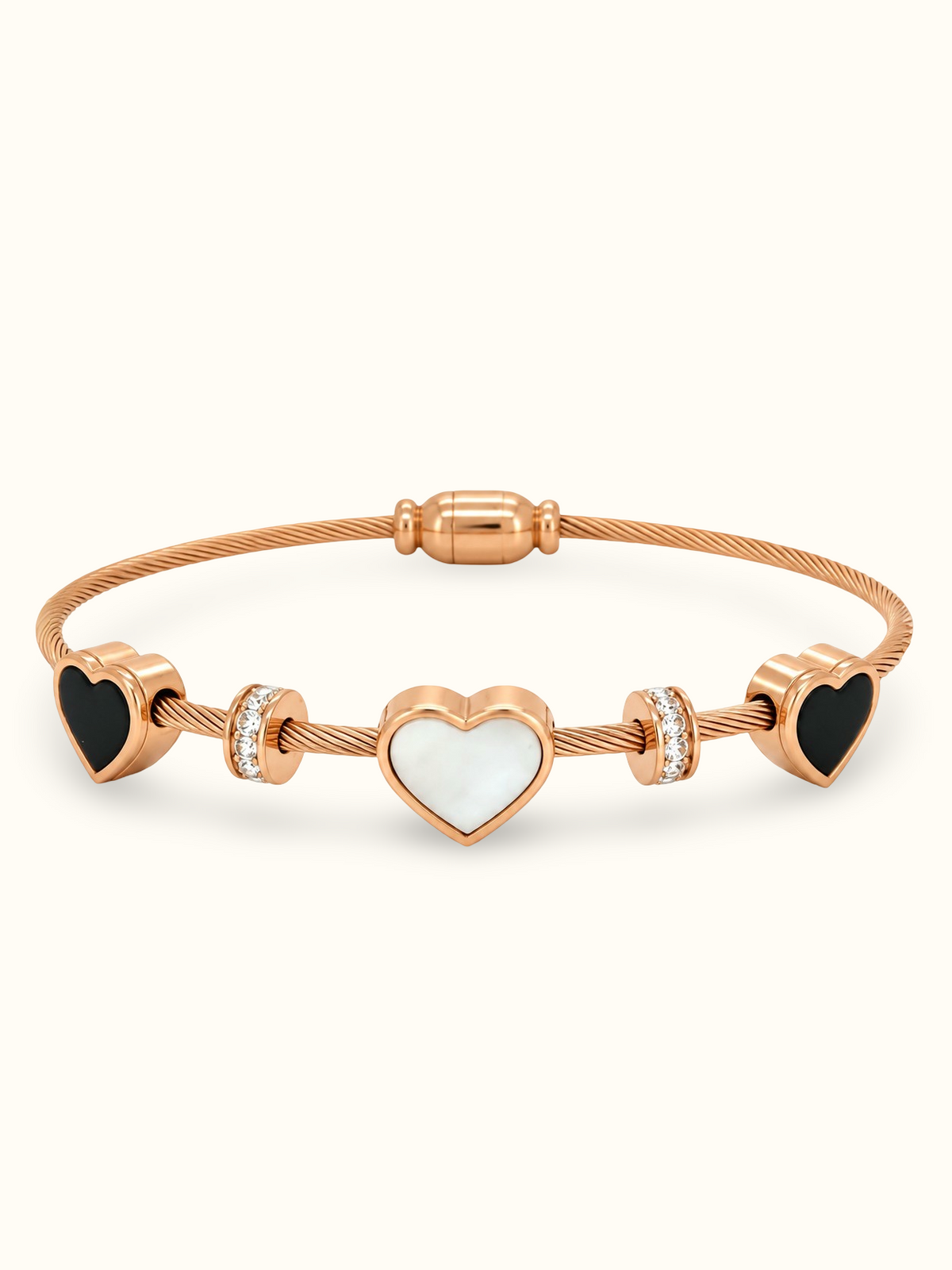 Rose gold stainless steel bracelet featuring three heart charms with black and white inlays and sparkling stone accents on a flexible wire band against a white background. 
