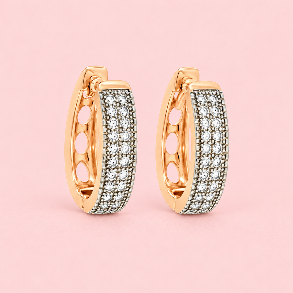 Rose gold-tone hoop earrings with clear sparkling stones and a dark textured base displayed against a pink background.