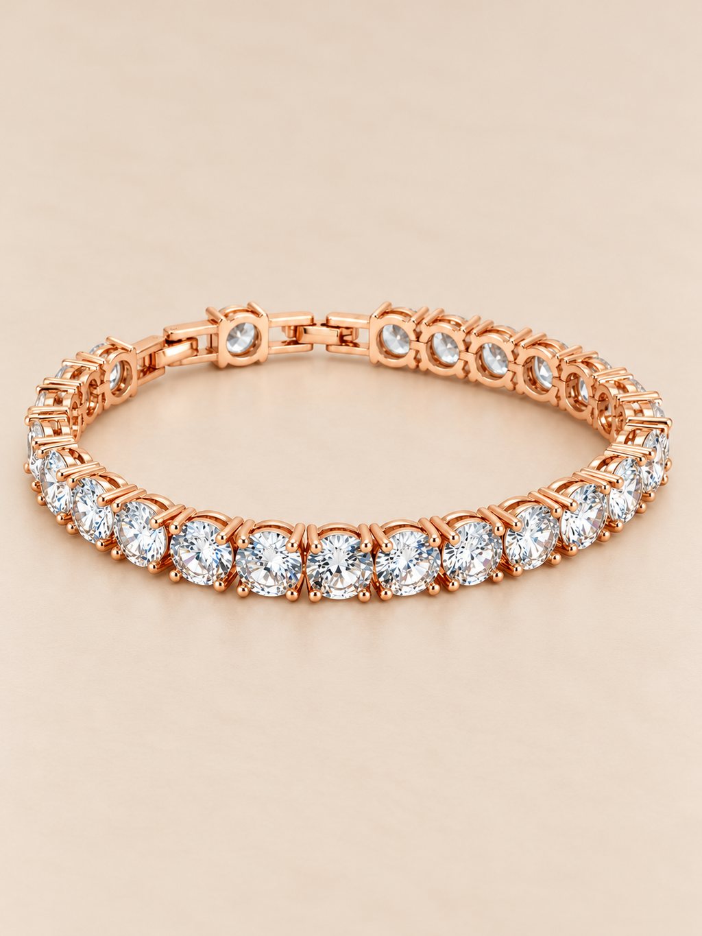 Rose gold-toned tennis bracelet featuring a continuous row of brilliant round-cut clear stones in prong-style settings.
Classic linked bracelet design with a sparkling finish, displayed on a clean pink background.