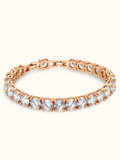 Rose gold-toned tennis bracelet featuring a continuous row of brilliant round-cut clear stones in prong-style settings.
Classic linked bracelet design with a sparkling finish, displayed on a clean off-white background.