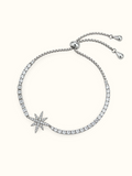 Silver-toned Celestial Starburst Bracelet featuring a multi-point star charm decorated with sparkling clear stones.
Adjustable bolo-style bracelet with round and square stone accents along the band, displayed on a light background.