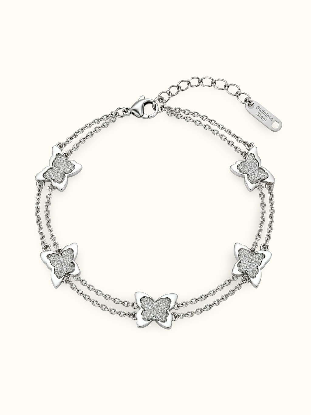 Silver-toned double-chain bracelet featuring five butterfly charms with glittery textured centres and smooth silver outlines.
Delicate layered butterfly bracelet with a lobster clasp and extension chain, displayed on a plain white background.