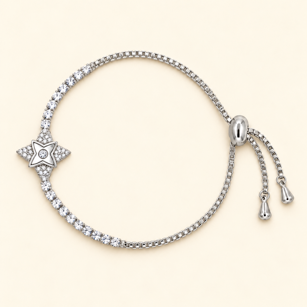 Silver-toned slider bracelet featuring a star-shaped centre motif with sparkling stone accents and a stone-studded chain.
Delicate box-link bracelet with an adjustable slider closure, displayed on a plain pink background.