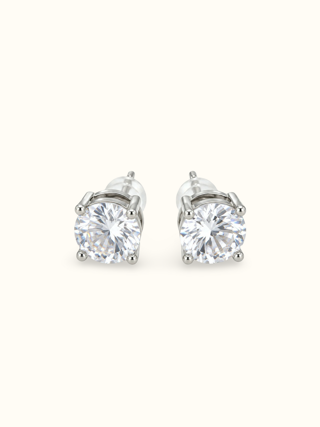 Silver-tone round solitaire stud earrings with large clear stones in four-prong settings.