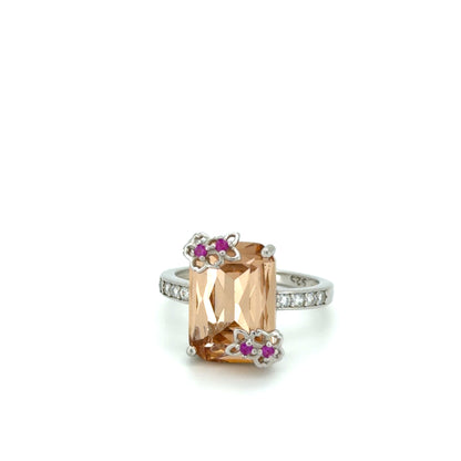 Sunset Blossom Solitaire Ring with a large orange gemstone and smaller pink stones on a white background