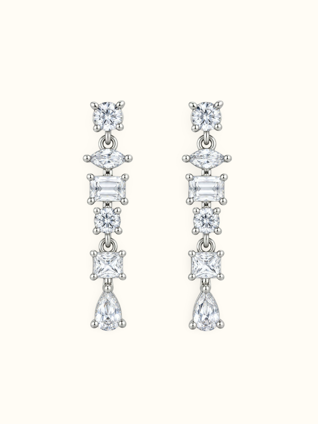 Silver-tone geometric drop earrings with round, marquise, rectangular and pear-shaped clear stones displayed against a white background.
