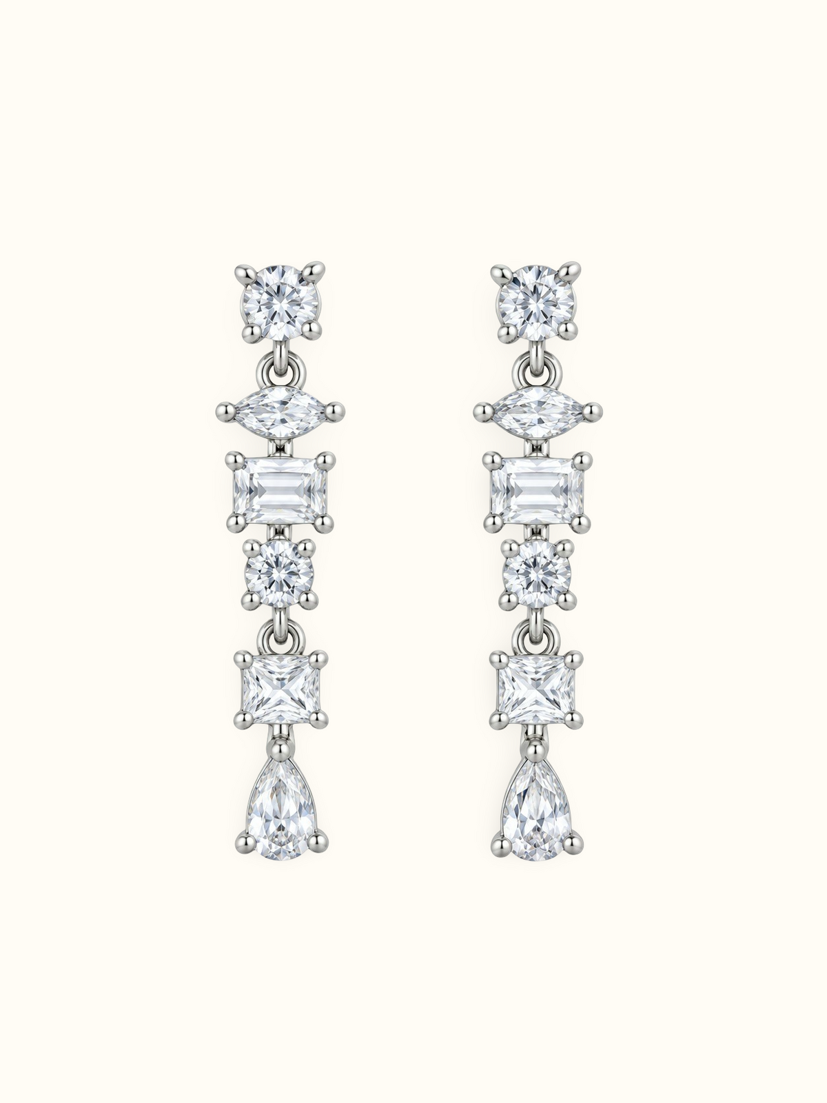 Silver-tone geometric drop earrings with round, marquise, rectangular and pear-shaped clear stones displayed against a white background.