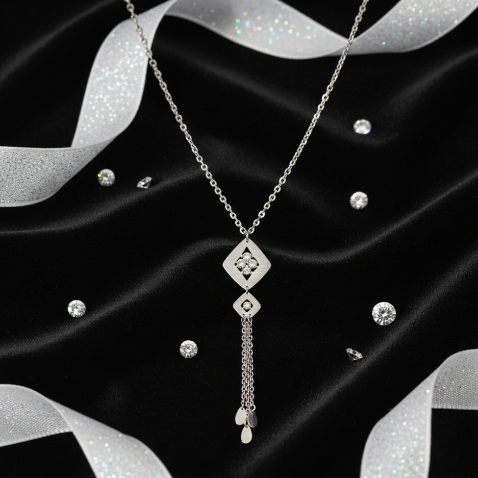 Silver necklace on a black fabric background with silver ribbons.