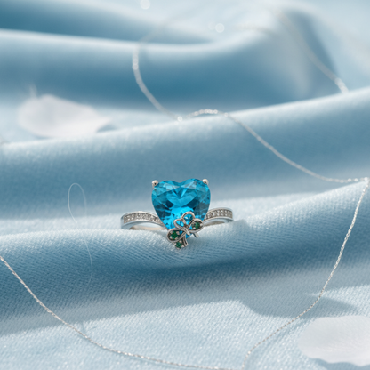 azure heart ring with a blue heart-shaped crystal gemstone on light blue fabric