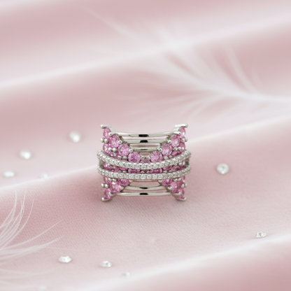 Stack of pink gemstone rings on a soft pink background. Alt: top view butterfly pink ring silver ring design with pave detailing