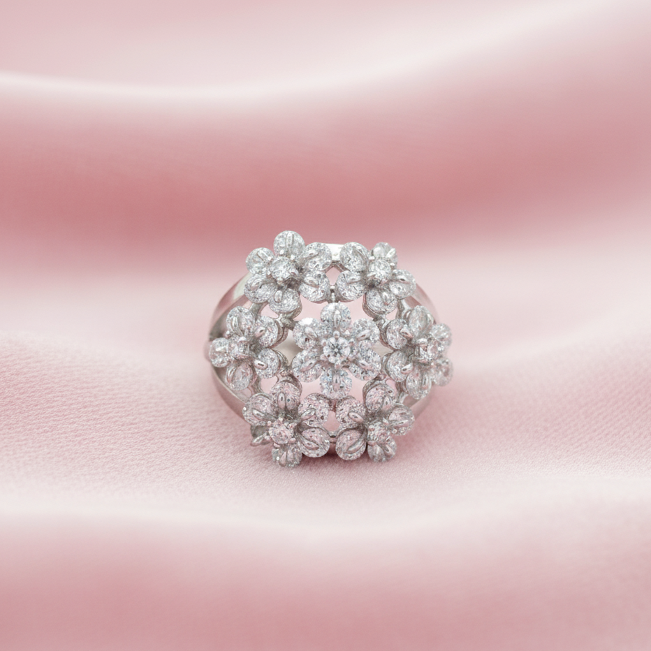 Silver floral-cascade-ring-modern-indian-jewellery ring with diamond cluster on a pink satin background