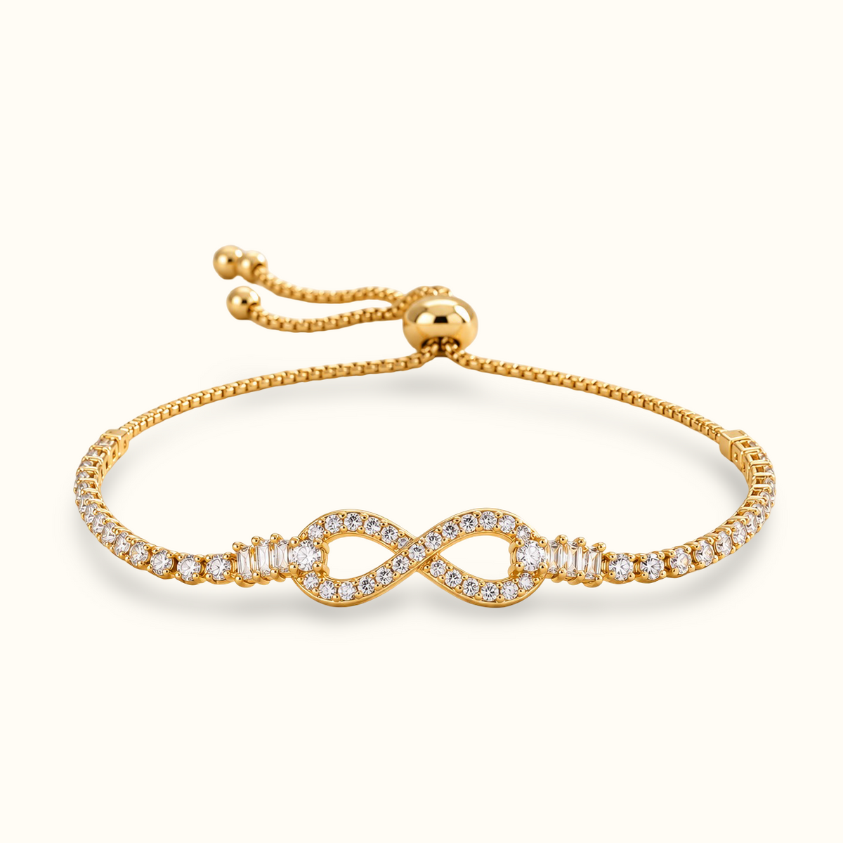 A delicate gold chain bracelet with a infinity design in the middle filled with diamonds and both sides has circle diamonds displayed against a light background.