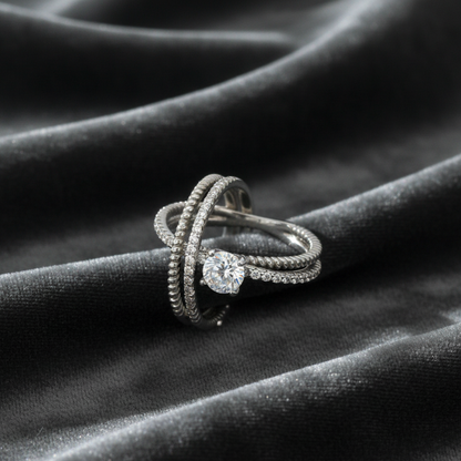 Silver ring with a diamond on a dark fabric background