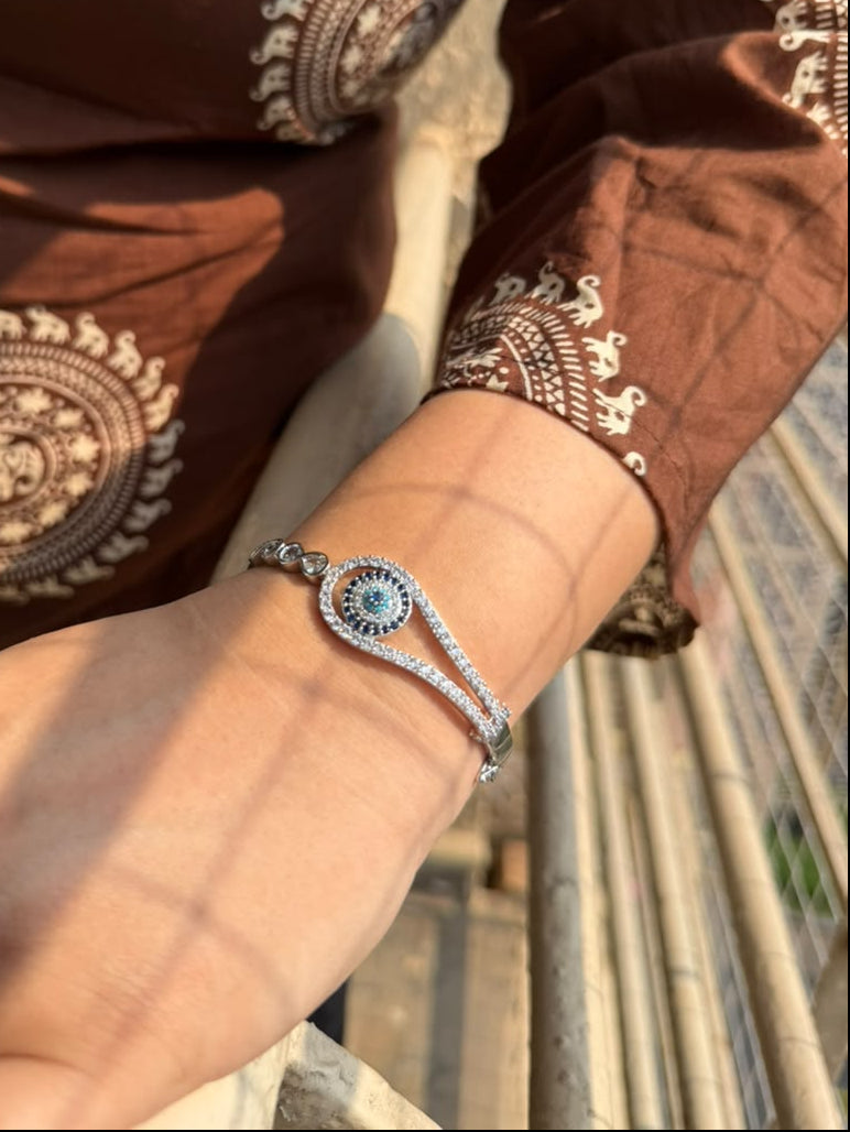 women wearing silver colored evil eye bracelet