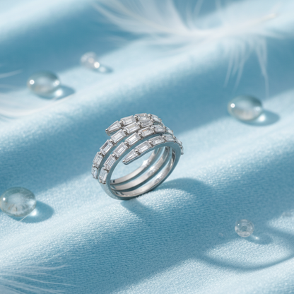 Silver spiral lumina ring by maelawith gemstones on a light blue fabric background